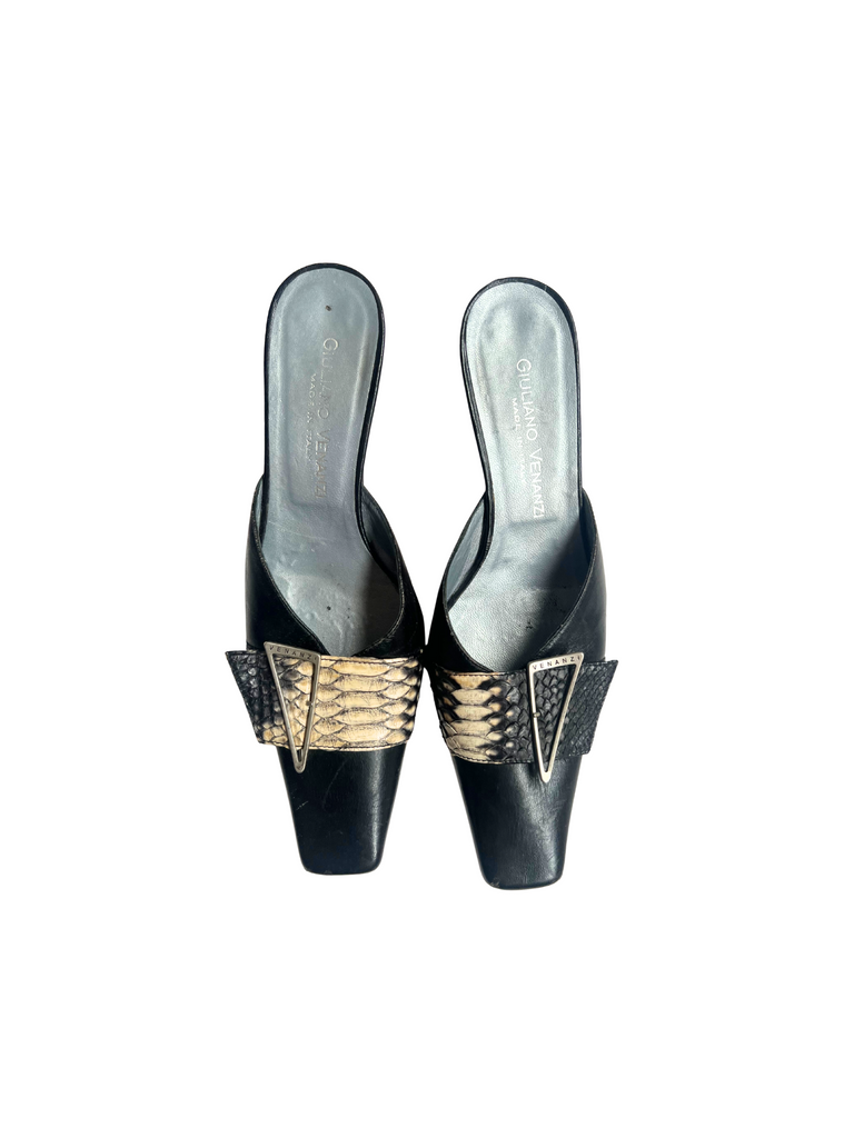 Pair of black high-heeled shoes with gold accents on a white background